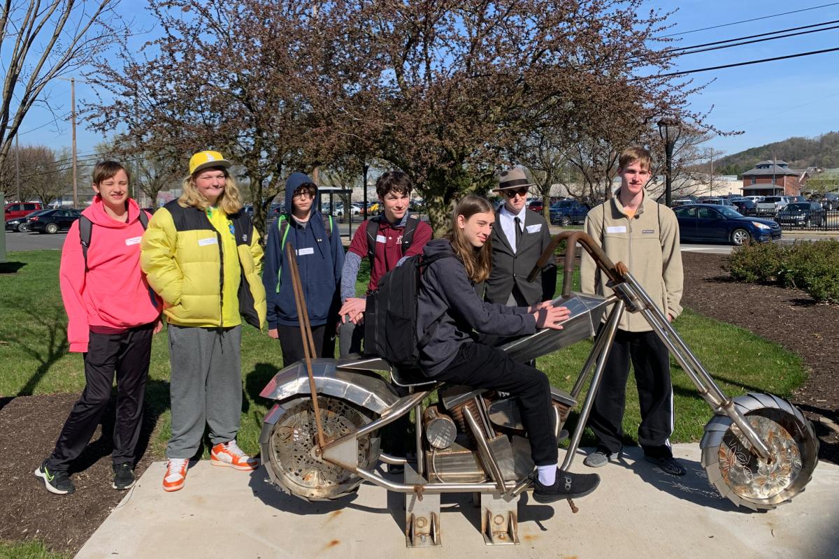 Chester County students enjoy a photo op at a campus hallmark: a motorcycle created by Penn College welding students and renowned metal artist Rae Ripple. 