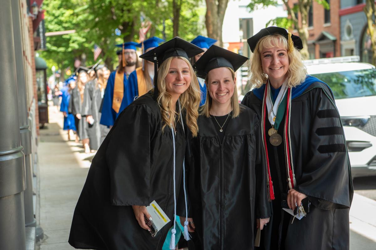 Tina M. Evans (right), associate professor of applied health studies, pauses to pose with her mentees in the processional line.