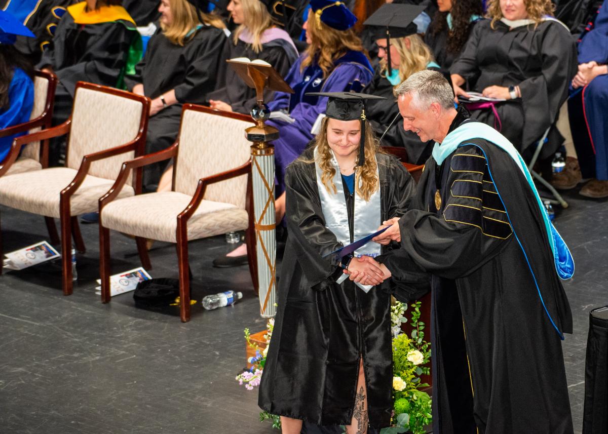 Kassidi D. Lenhart, a member of the Wildcat women's basketball and tennis teams, is greeted by the president. Her major (not surprisingly, given her student-athlete status): business administration: sport & event management concentration.