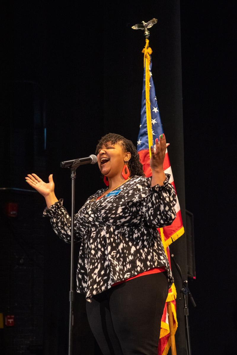 A stellar vocalist, Tamaka F. Carter belts out the national anthem. The financial aid assistant sang at both Saturday ceremonies.