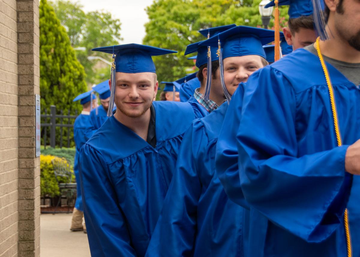 Having fun near the end of a long line of graduates that snaked to the Genetti Hotel pool is Logan S. Halterman, who earned a degree in diesel technology.