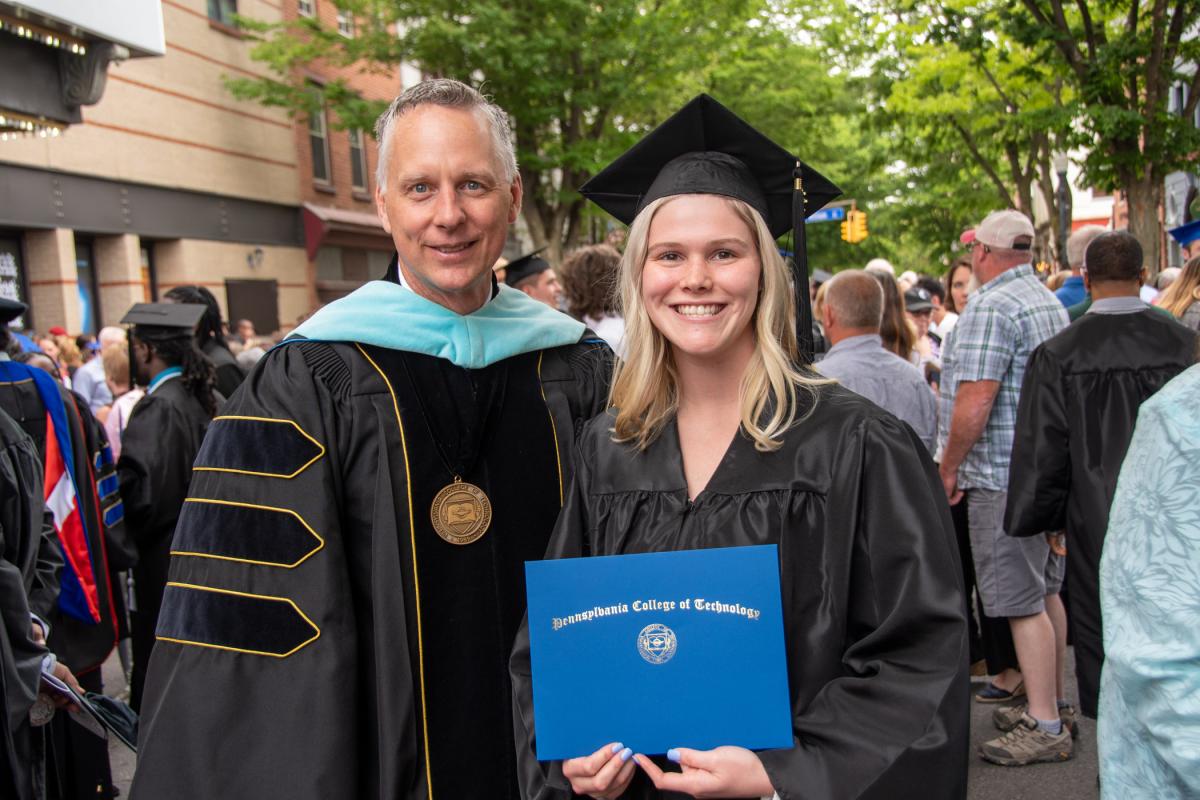Hannah M. Weaver secures a photo opportunity with President Reed. Weaver received a degree in civil engineering technology.