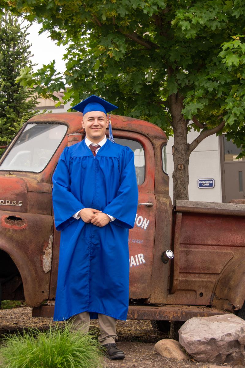 Jace I. Eisen, a welding technology grad, has his photo taken before a popular campus landmark: A 1949 Dodge truck, refitted as a water feature by the college’s General Services and collision repair/automotive restoration departments.