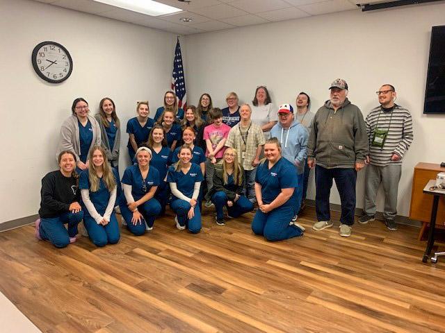 Graduating dental hygiene students gather with clients at Hope Enterprises.