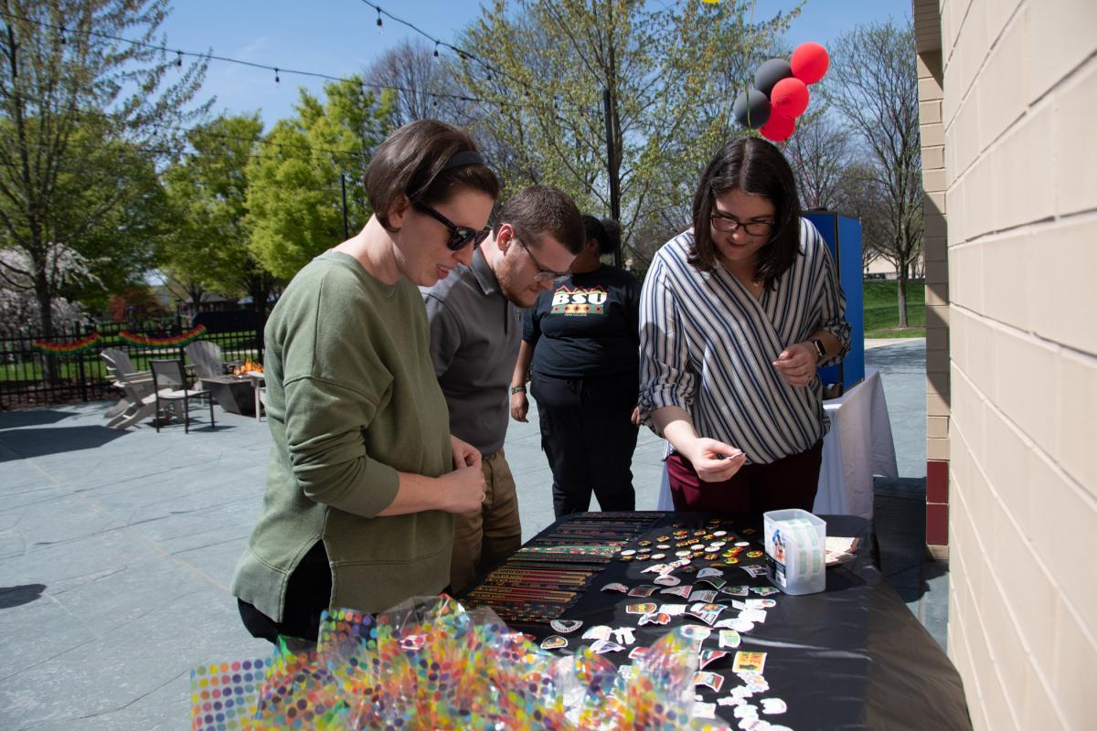 Checking out wearable symbols of the celebration are Sarah R. Yoder, coordinator of admissions operations; Bryce W. Winder, coordinator of admissions events and communications, and Jen Cullin-Hetrick, associate director of admissions.