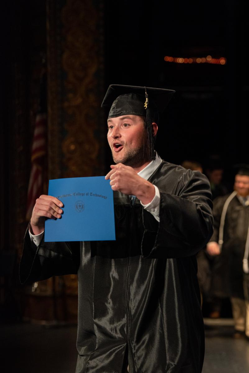 A fresh four-year graduate in heating, ventilation & air conditioning engineering technology provides proof to a video camera of his accomplishment ... but we believe you, Andrew C. Giffi. You did it!