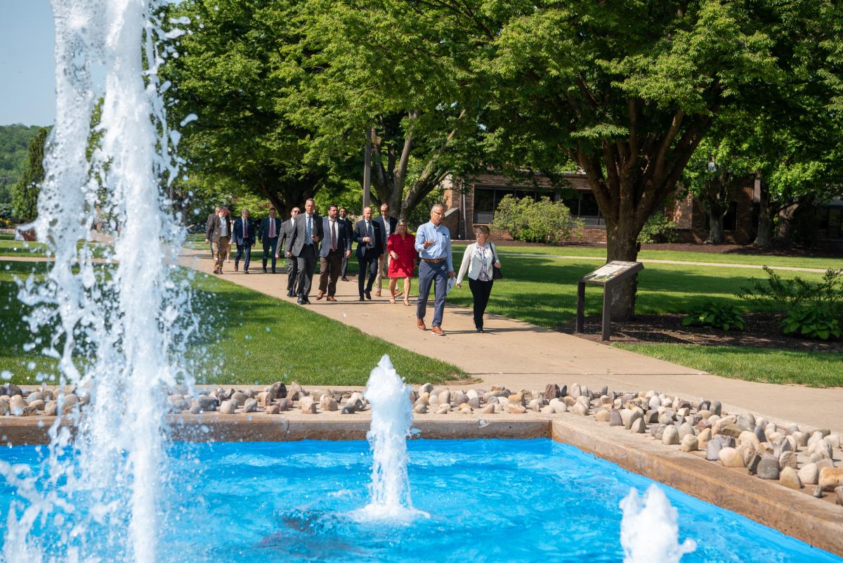 Crossing campus on a beautiful Thursday in the Keystone State, the group passes the Veterans Fountain. Leading the lineup is Loni N. Kline, senior vice president for college relations/chief philanthropy officer, talking with George Stark, director of external affairs at Coterra Energy.