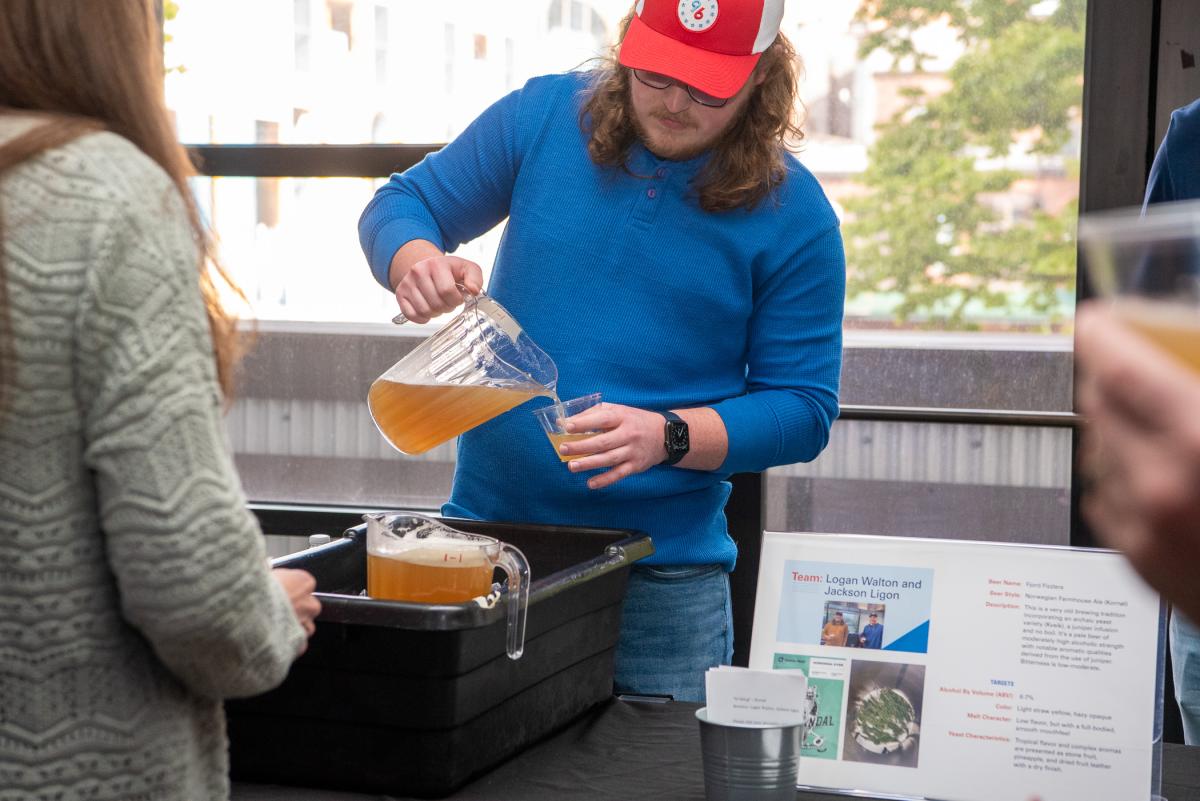 Walton pours a sample of the Norwegian farmhouse ale in the arts center's Capitol Lounge.