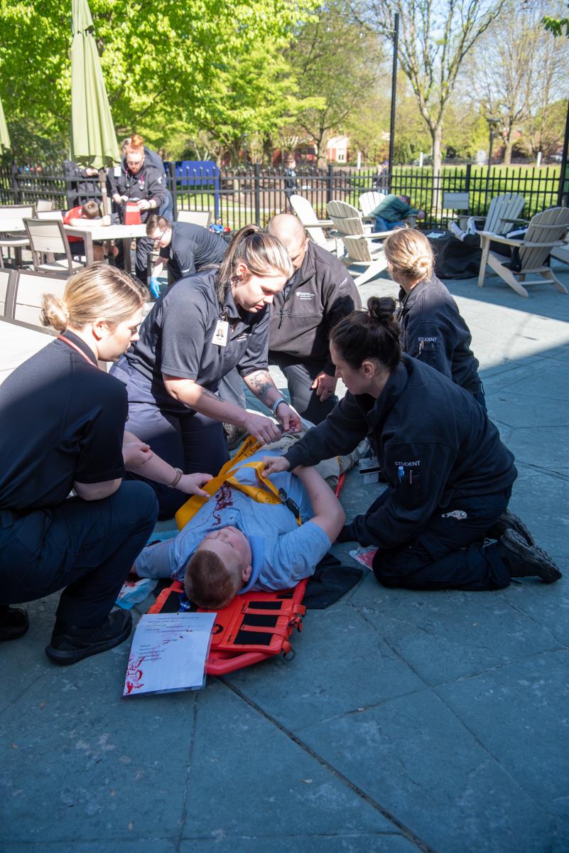 Paramedics load the most critical “patient” onto a stretcher. 