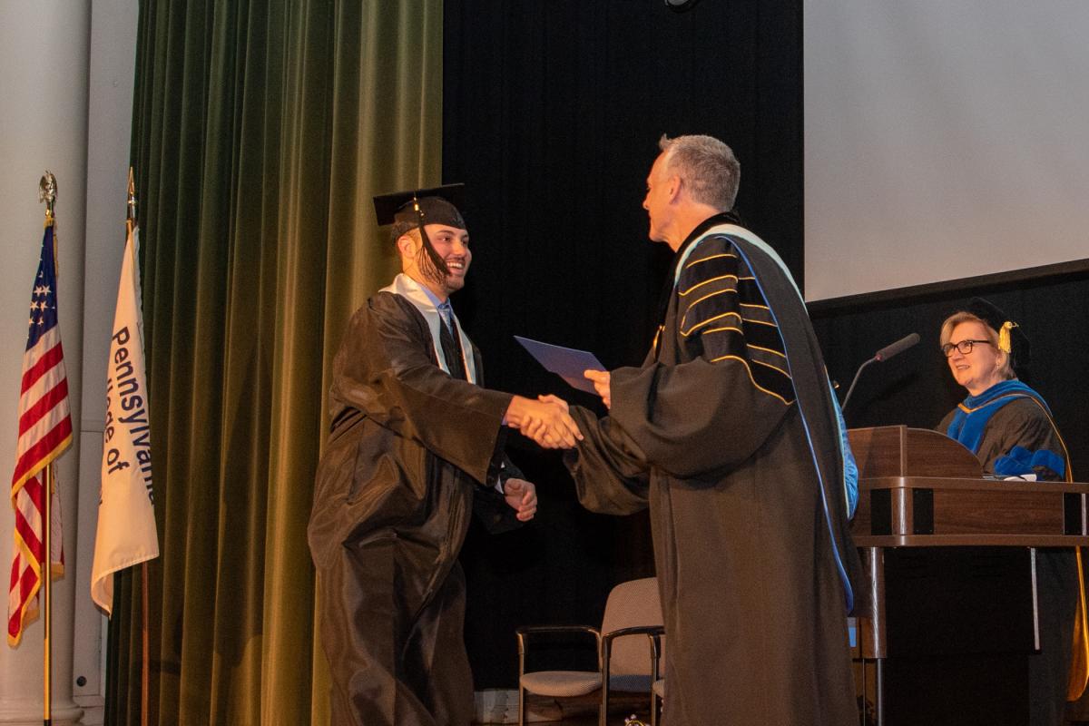 Cameron S. Dick crosses the stage for the presidential seal of achievement.