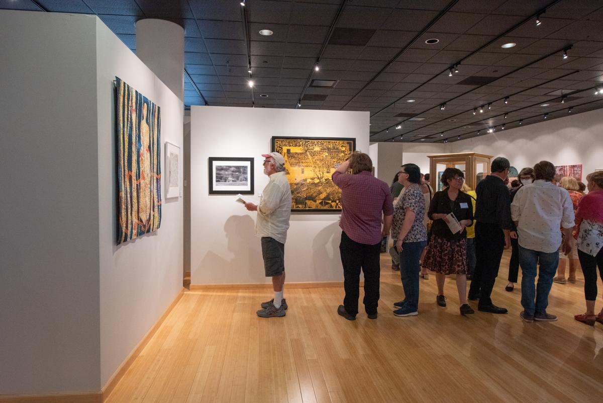 The gallery gradually fills with more reception guests eager to take in the images.