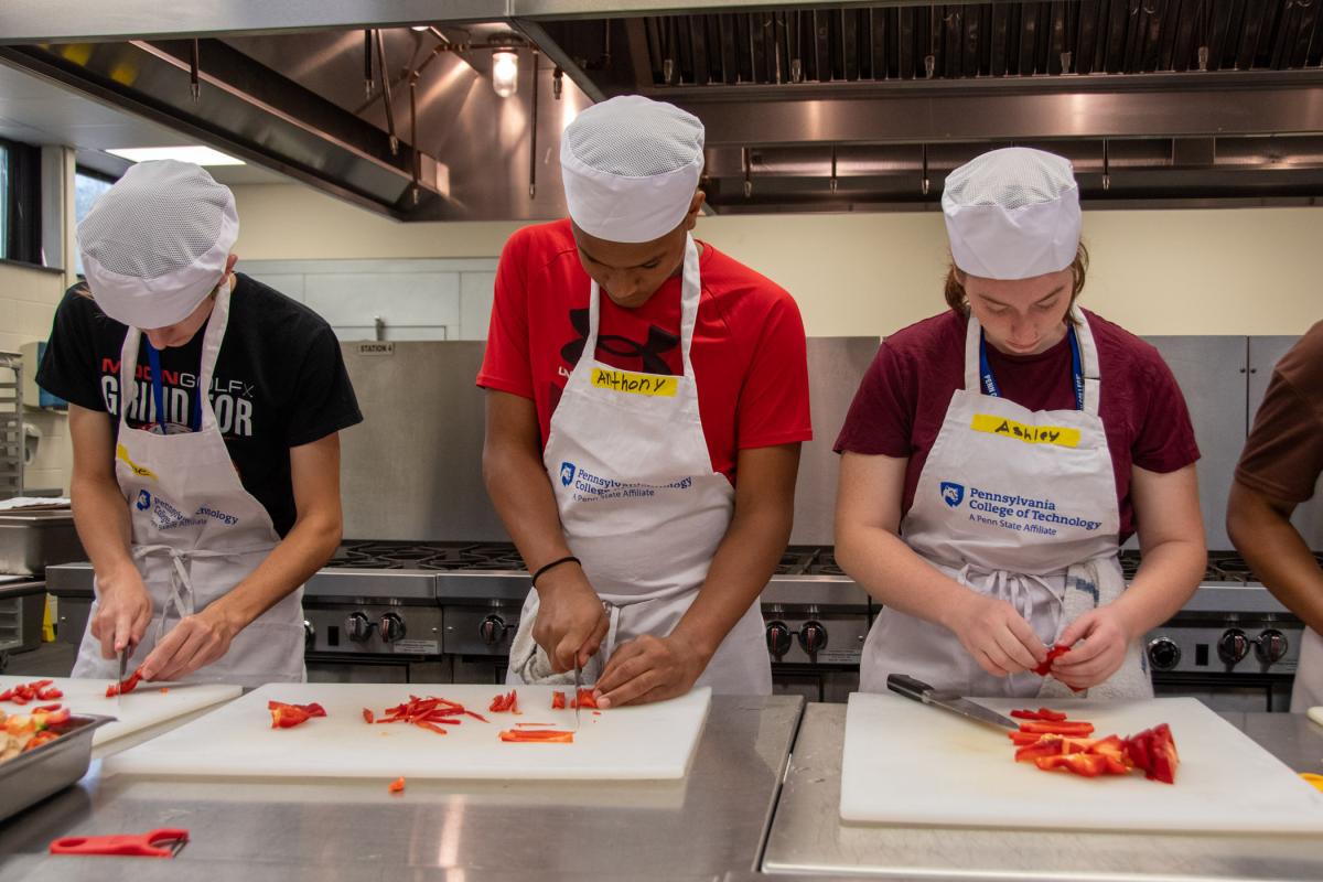 Future restaurateurs julienne their peppers to match-stick thickness for a dish that will be served to their families at the end of the program.