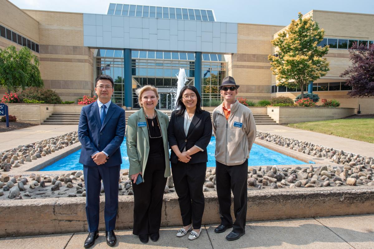 The group pauses in its travels in front of the Veterans' Fountain. From left are Hector Liu, general manager of Beijing Prepare Education Technology Co.; Nesli Alp, vice president for academic affairs/provost; Qiong Lee, the consultancy's international program manager; and Bradley M. Webb, dean of engineering technologies.