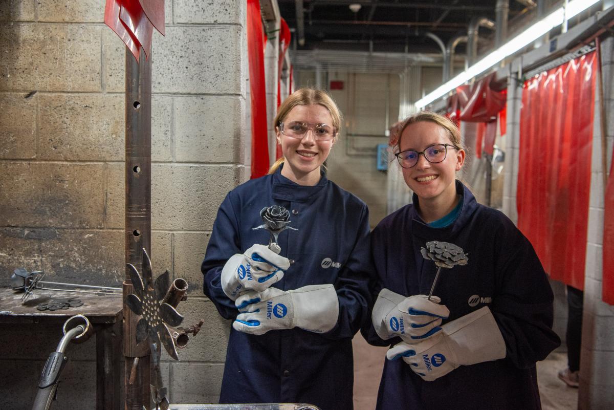 A completed rose (at center) and one yet to be finalized (on right) bloom next to another camp creation: a sunflower (at left). 