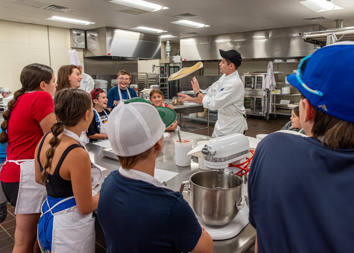 Dining Services' Christopher R. Kelley dazzingly amuses his audience in an exhibition of dough-tossing.