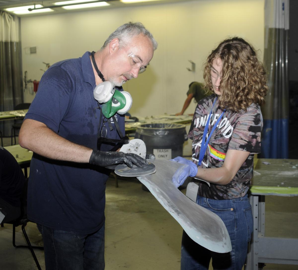 In the Automotive Restoration program, a camper is assisted by collision repair instructor Roy H. Klinger in prepping her vehicle fender ...