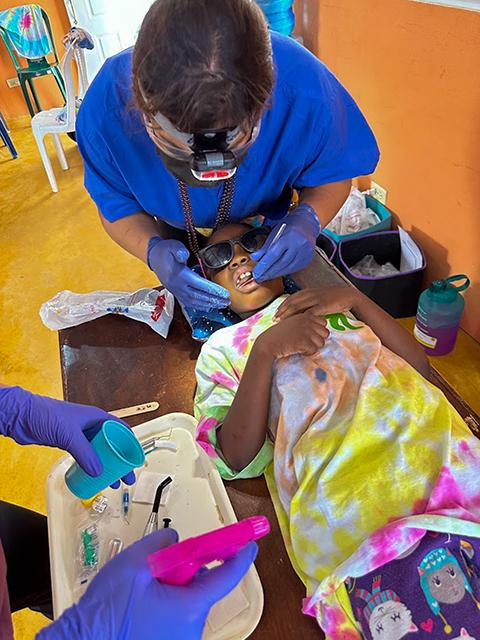 Penn College student Claudia D. Friskey, of Prospect Park, provides oral health care to a child.