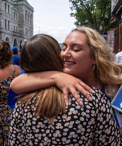 Brittany N. Neeper, a surgical technology grad from Lancaster, shares a hug with a supporter.