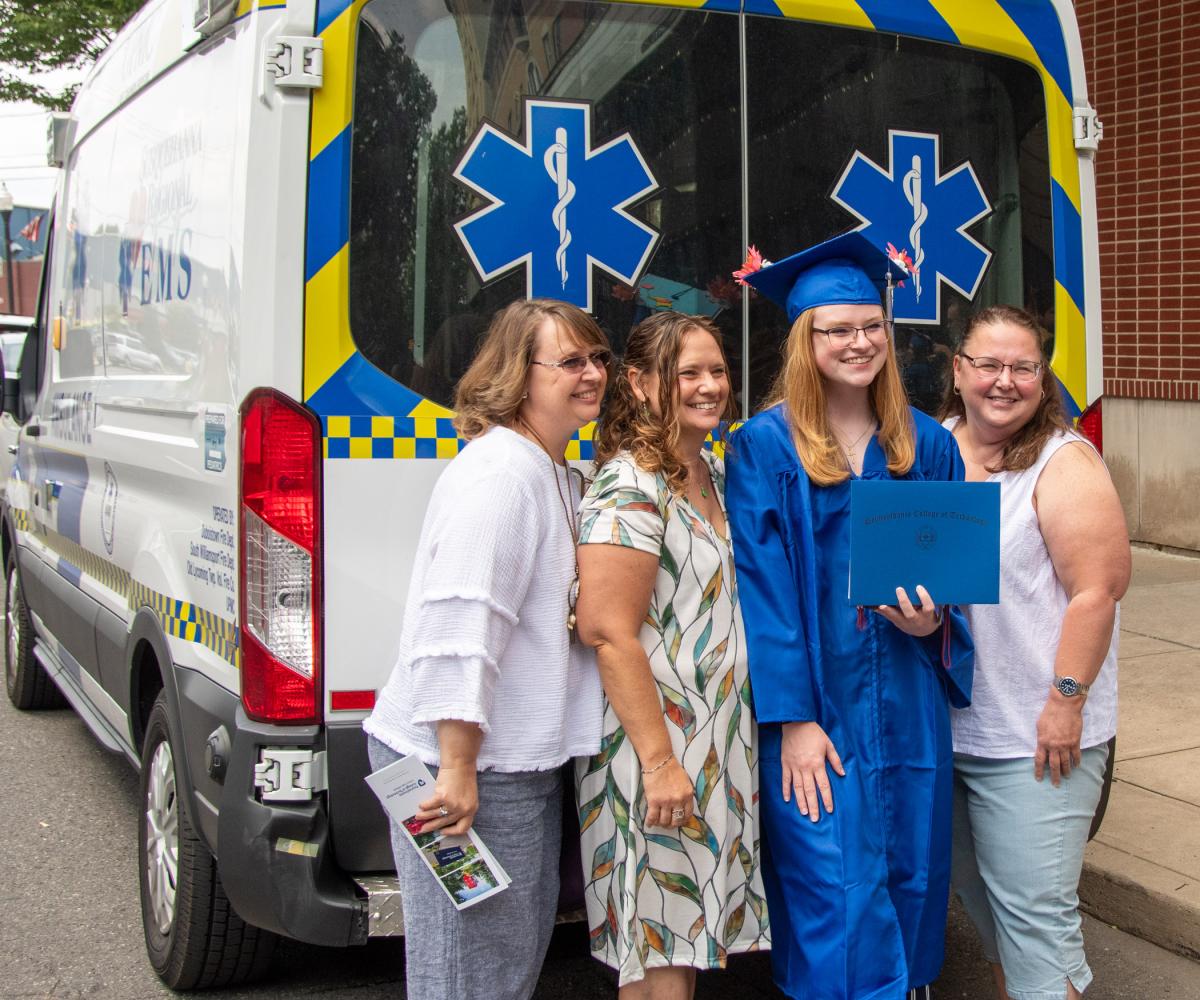 Paramedic science grad Breyanne E. Johnson, from Danville, finds an appropriate photo backdrop.