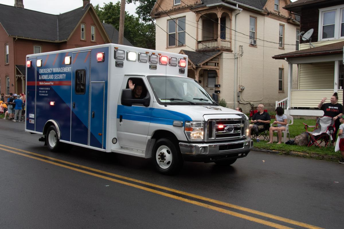 David E. Bjorkman, instructor of emergency management/social science, waves from the college’s Mobile Command Post, a new “tool” for the emergency management & homeland security major.