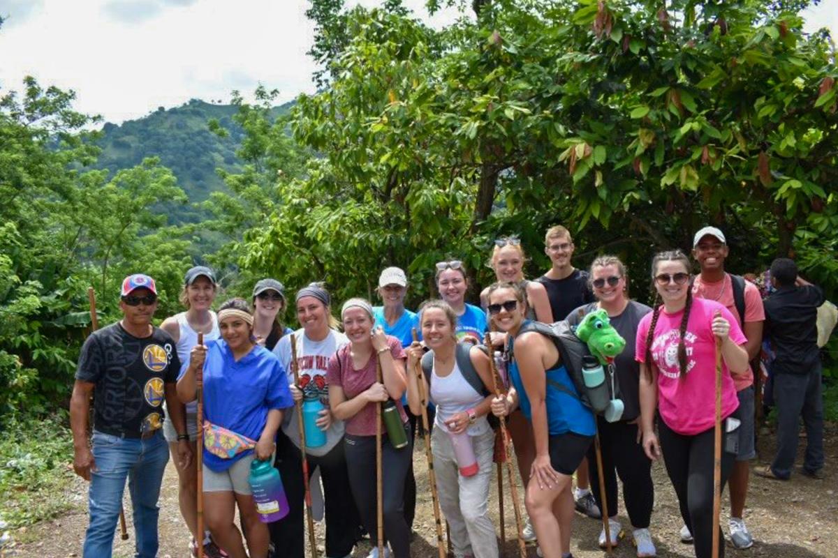 The crew – including dental education plush Al E. Gator – gathers before ascending a mountainside to provide dental hygiene services in the Dominican Republic.