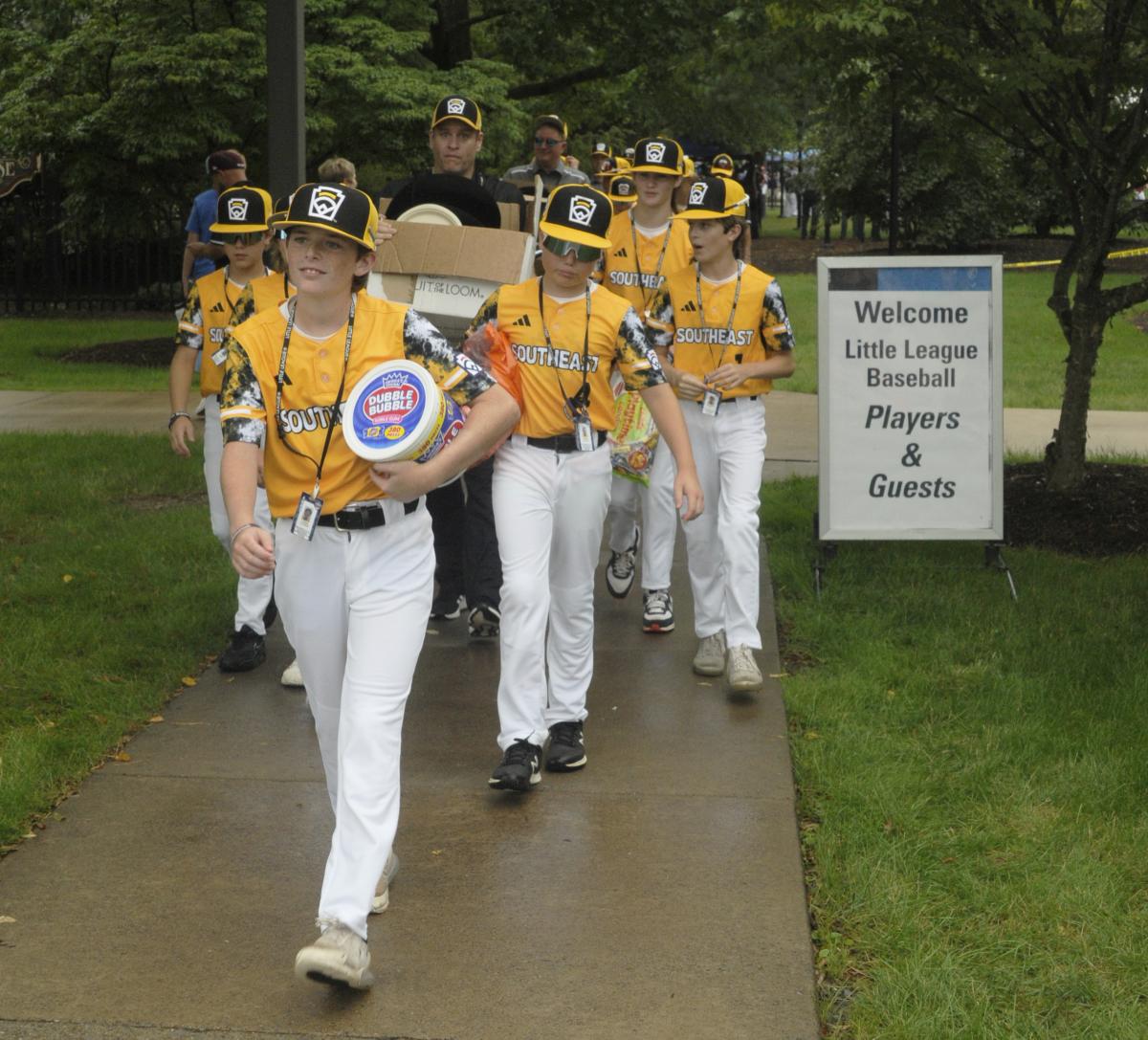 Led by bubblegum-toting catcher Corbin Cyphers, the Southeast players return to their bus for transport to the parade staging area.