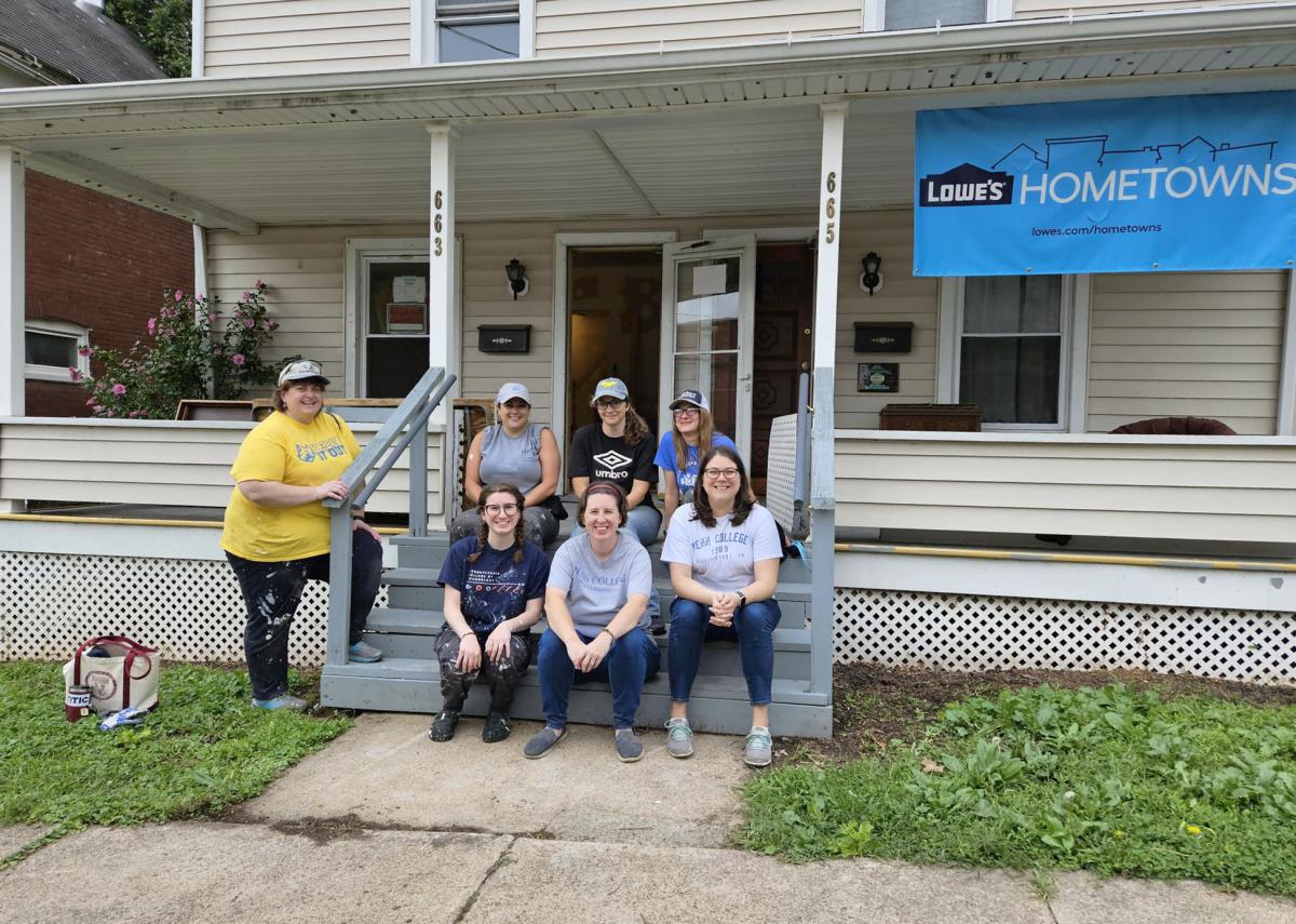 Community-minded Admissions co-workers pause on the porch at 663-665 Center St. in Williamsport in the midst of their labors.