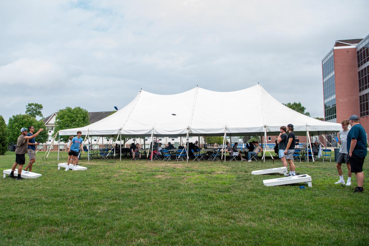 Cornhole with a big tent backdrop! 