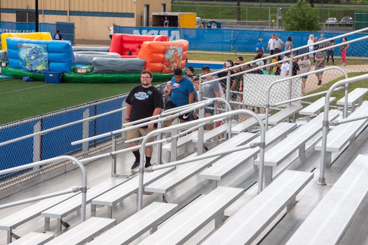 RA Kellor A. Schooley leads the first convocation arrivals to the bleachers (as sprinkles begin to fall). 