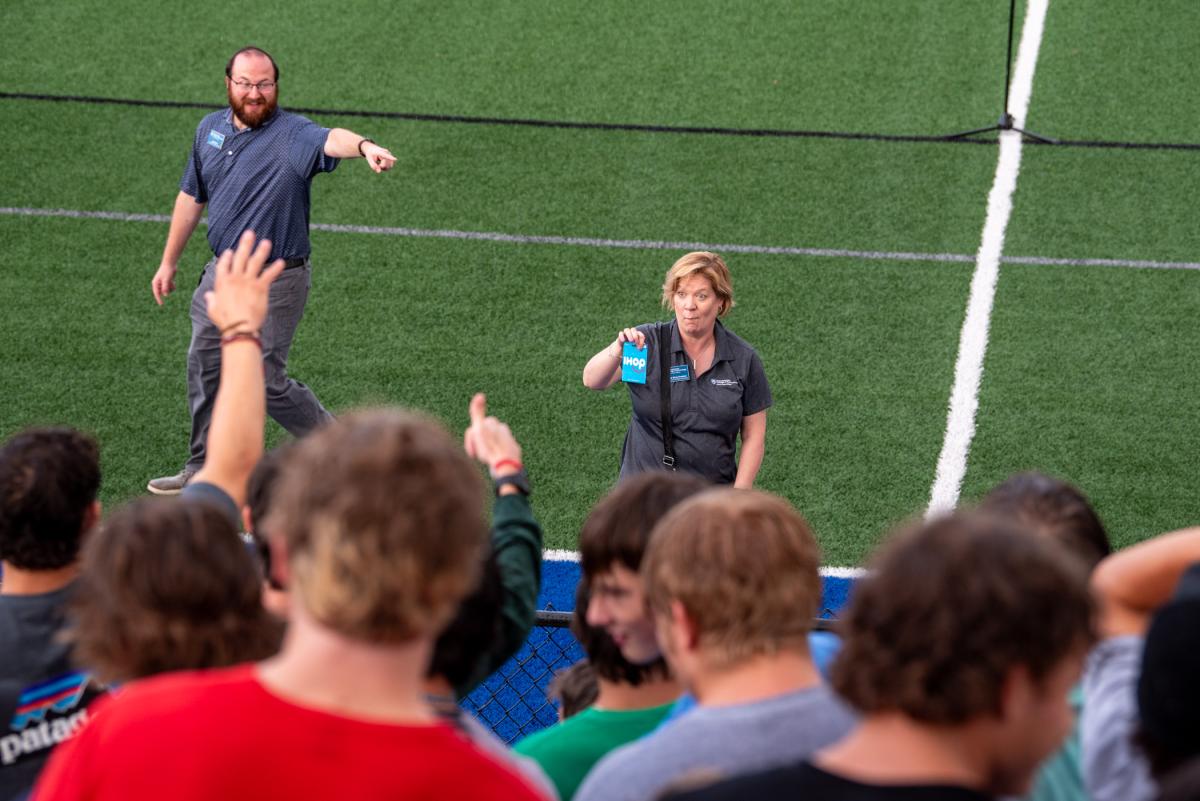 Using every talent in her toolkit – exuberance, unabashed promotion, expressiveness, gentle goading, eye contact and dance moves, among 'em – Christie A. Bing Kracker, director of the Center for Academic Excellence, works the crowd ... to the undisguised amusement of co-worker Kyle W. Kern, coordinator of student success.