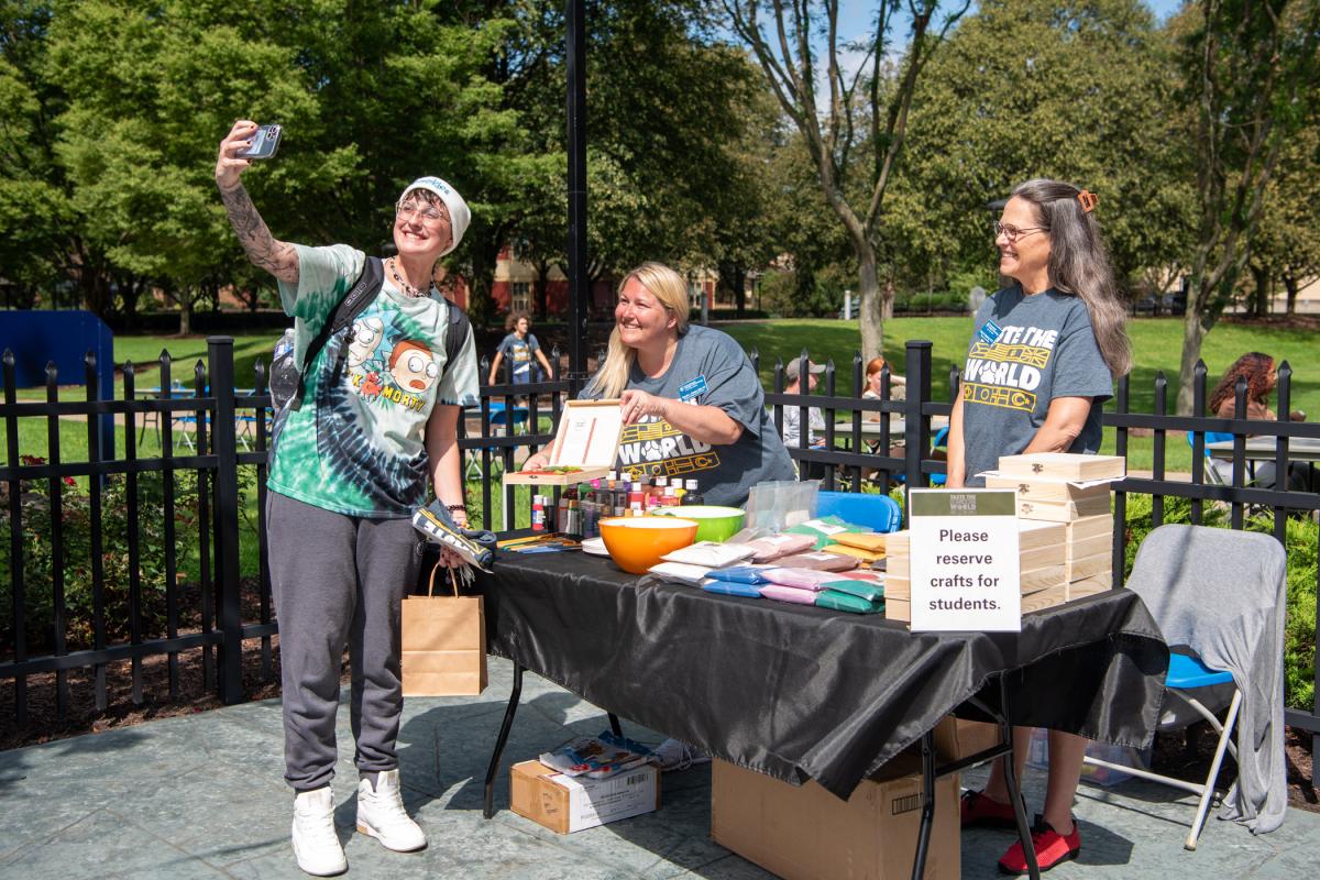 At a “Zen garden” crafts-to-go table, Tessa L. Pavlova snaps a selfie for her First Year Experience class with Wendi L. Snyder, director of College Health Services, as Mary R. Shuma Rudberg (at right), director of counseling, looks on. Pavlova is enrolled in pre-surgical technology.