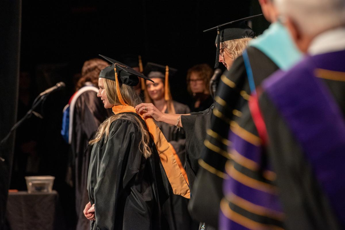 The hooding process for the college's first master's grads in nursing – including Nicole B. Cowperthwait, recipient of the Academic Vice President and Provost’s Award – signifies success in completing the graduate program.