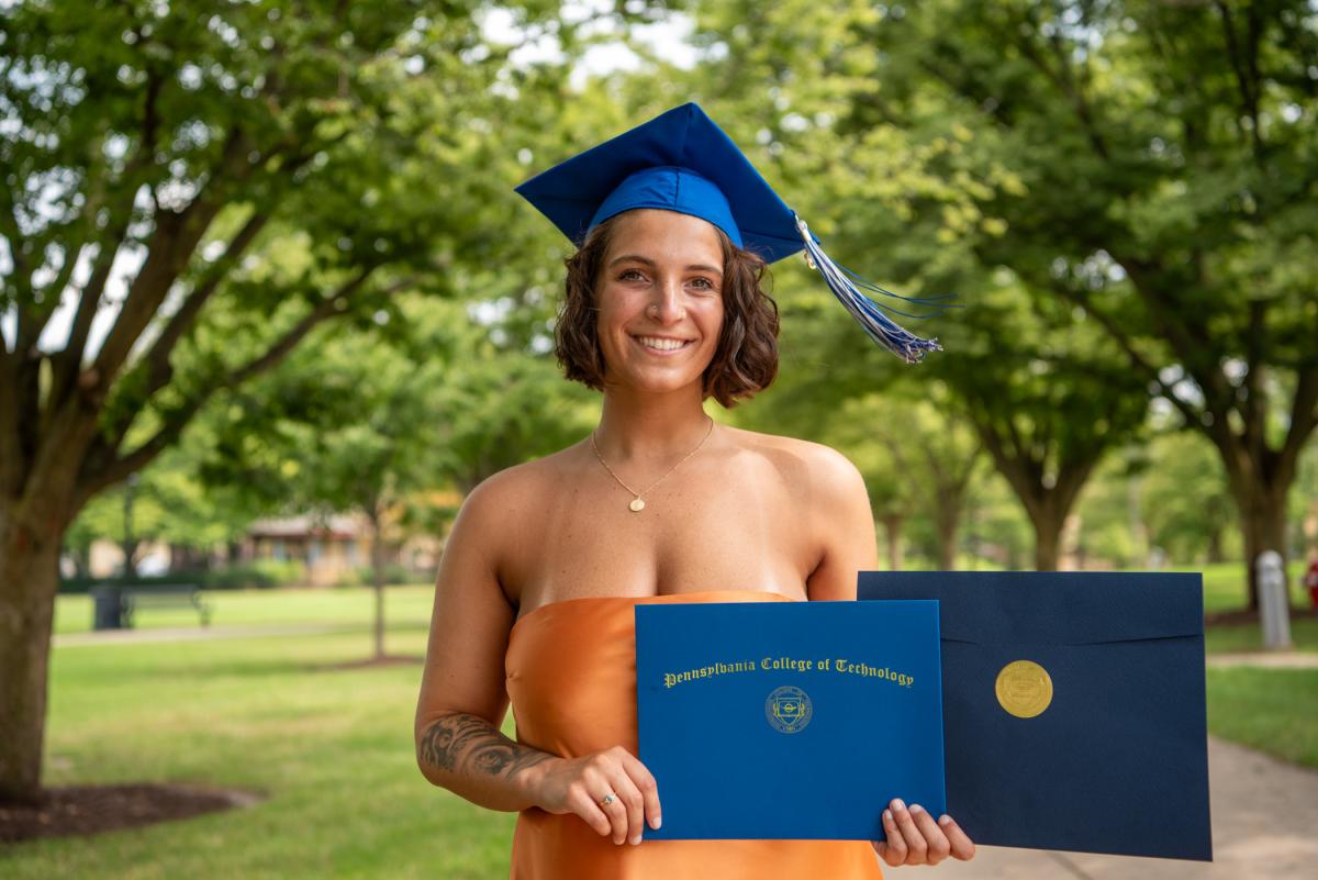 On the campus mall, Gabrielle P. Krupilis poses with her diploma holder and her Surgical Clinical Performance Award, presented to a graduate who has demonstrated outstanding clinical performance and professionalism in surgical technology.