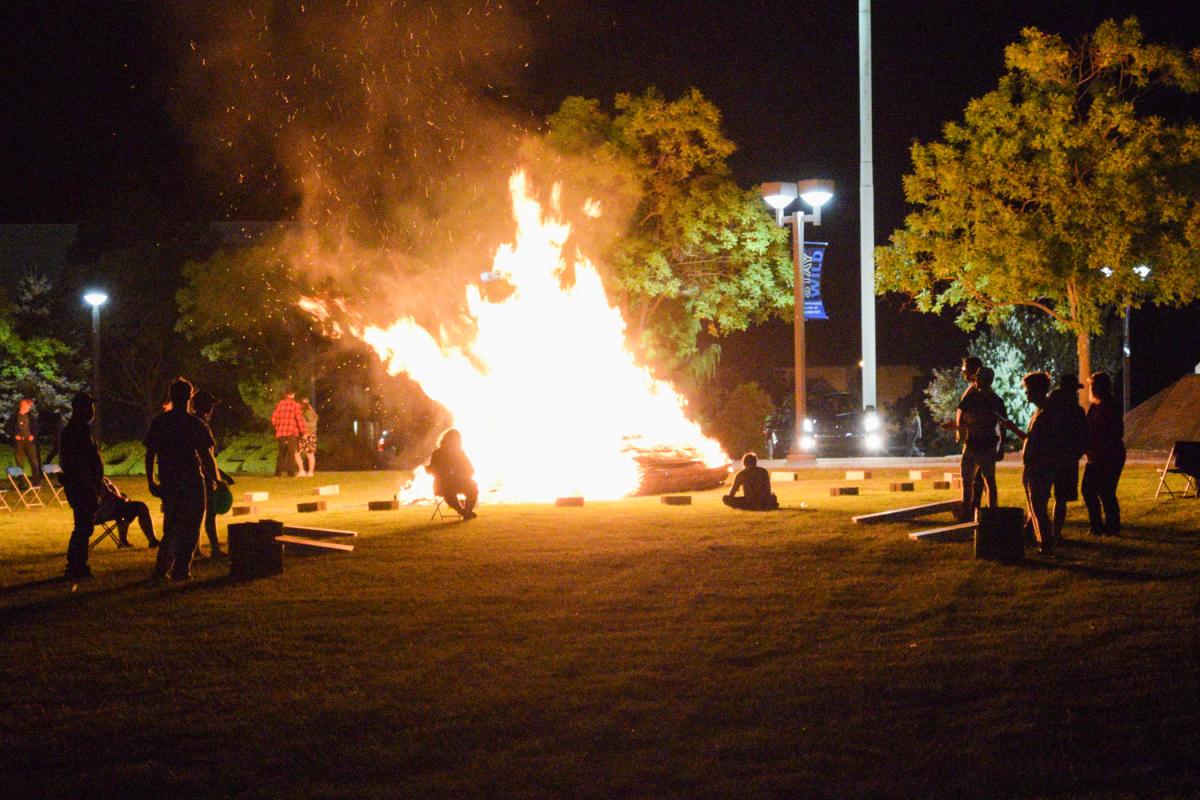 Friday's bonfire lights the night, a temporary wall against impending chill.