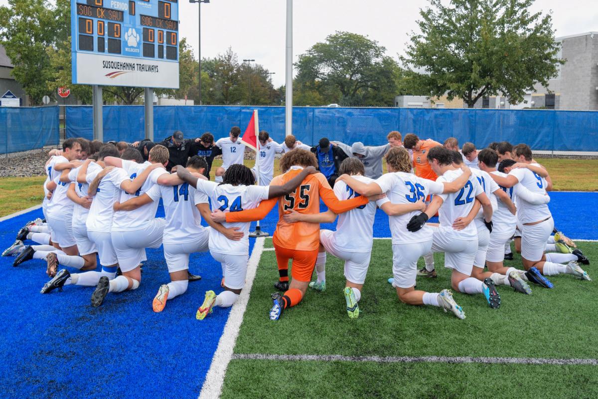 The Wildcat men's soccer team reverently huddles before its match against Penn State Berks.