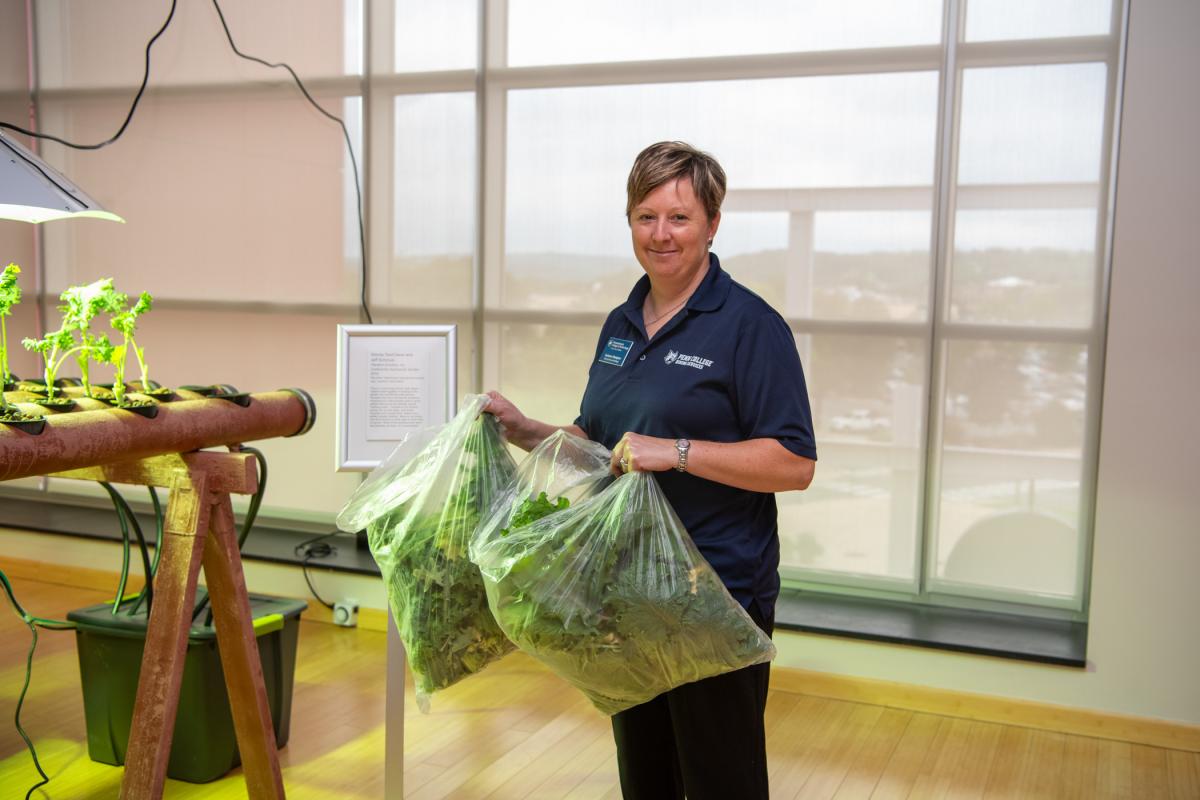 Hampton shows the two large bags of kale gathered from the first harvest. 