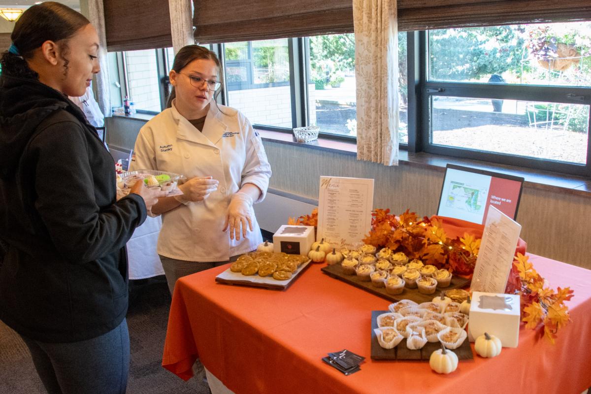 Autumn B. Stanley, of Lincoln University, interacts with a visitor. Her Autumn Breeze Café shares such treats as white chocolate pumpkin cookies, sweet potato cupcakes, and pecan praline cheesecake.