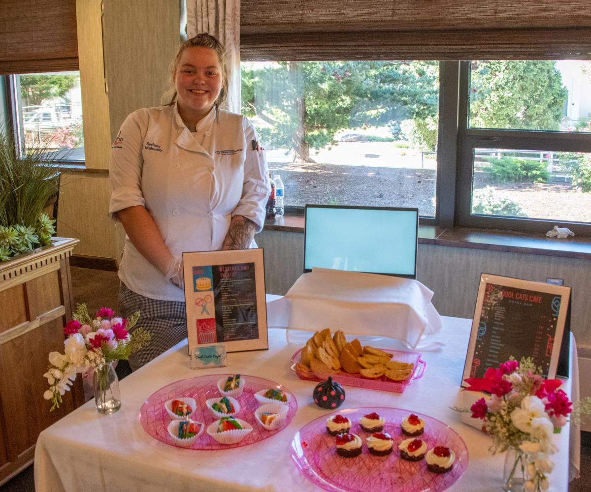 Sydney L. Mahoney, of Roaring Spring, presents Cool Cats Café, with rainbow bagels, strawberry cheesecake cookies, and chocolate cake with whipped cream and cherry pie filling.