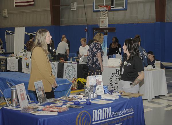 At the NAMI display, Detrick (left) meets Krystle J. Richardson, representing the HSJ Club and completing her senior year in the human services & restorative justice bachelor's major.