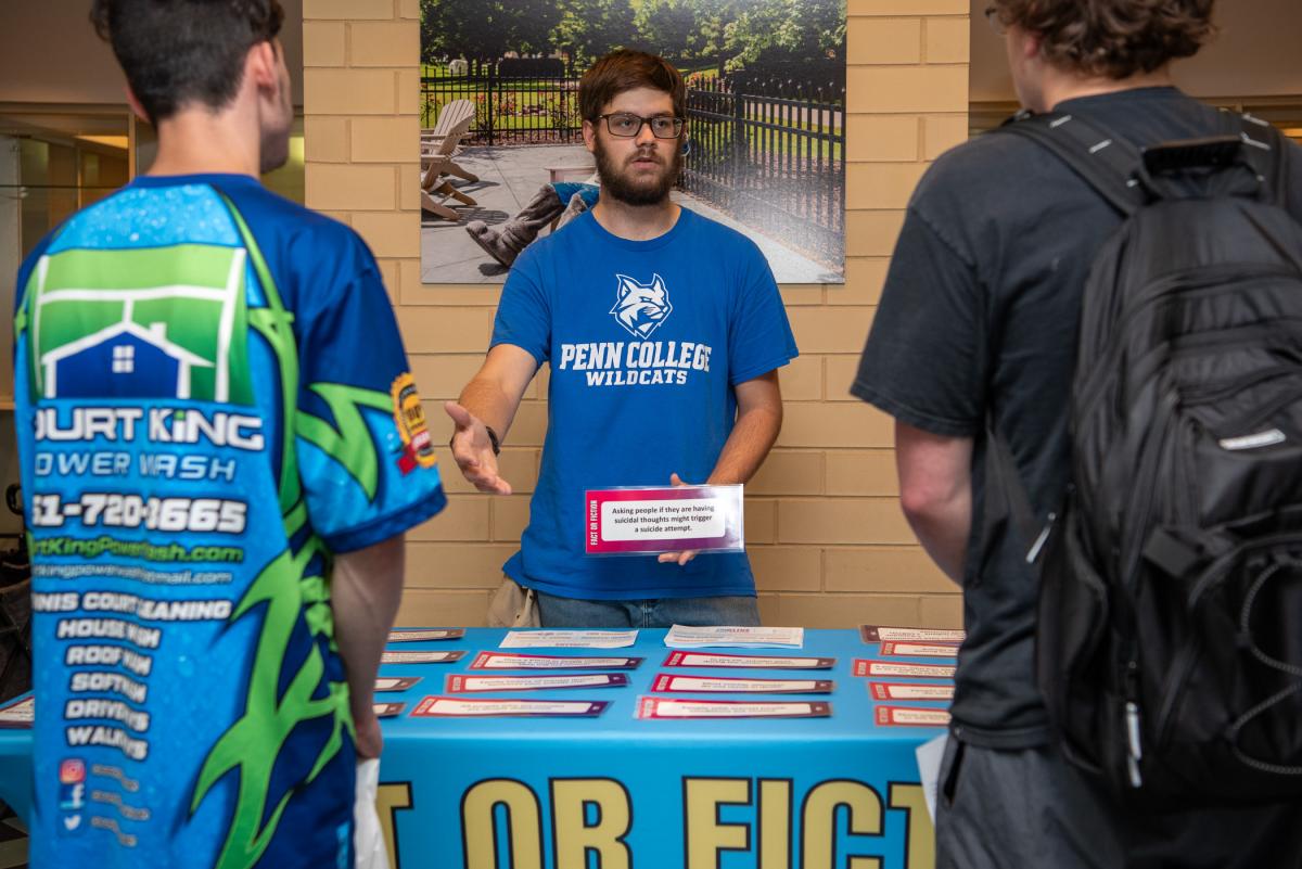 Jacob A. Krautheim, a freshman in building construction technology, volunteered to staff a table at the fair. Here, he leads fellow students through a “fact or fiction” exercise. 