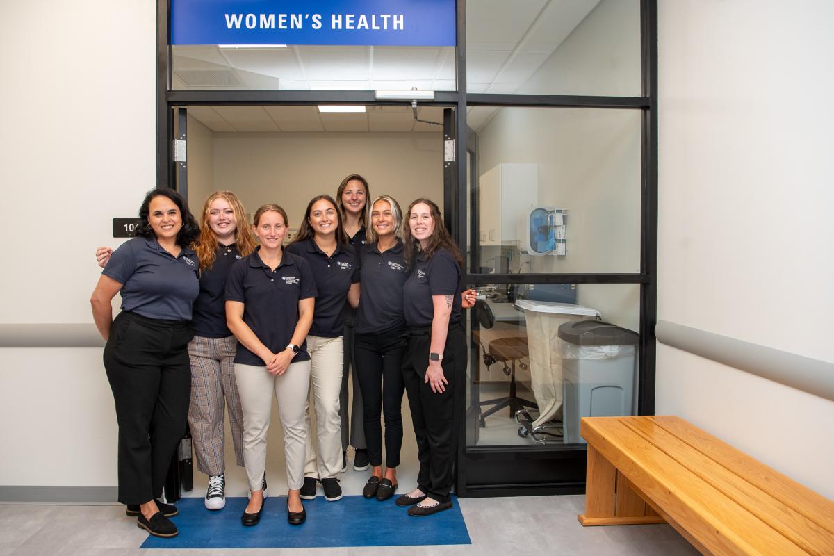 Students are framed in the doorway of the Women’s Health lab. 