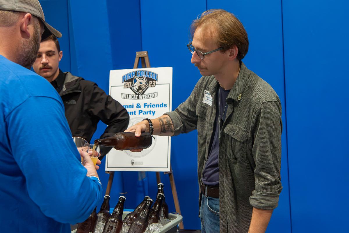A member of the college’s inaugural brewing class, William B. Ernst-Wingfield, brewer at John Ryan Brewery, pours a sample at the Alumni & Friends Tent Party (moved inside despite its original "in-tent"). 