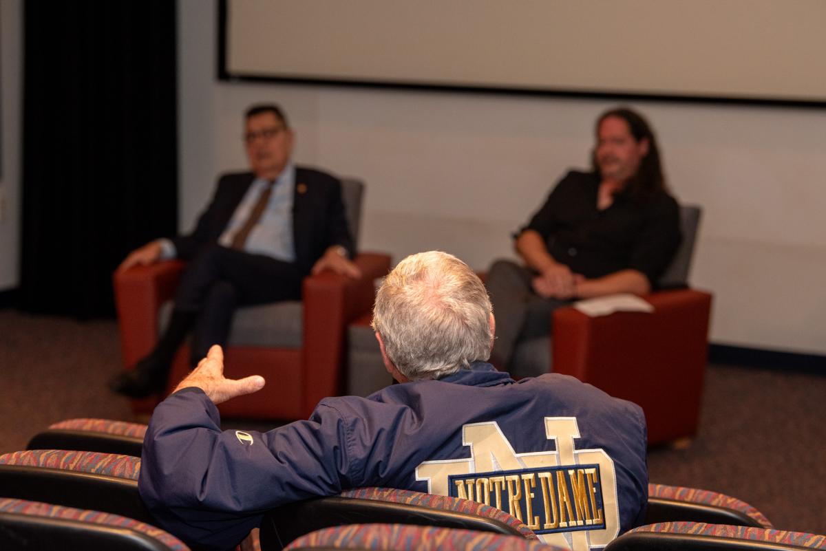 His jacket making clear his Fighting Irish allegiance, an attendee adds to the dialogue.