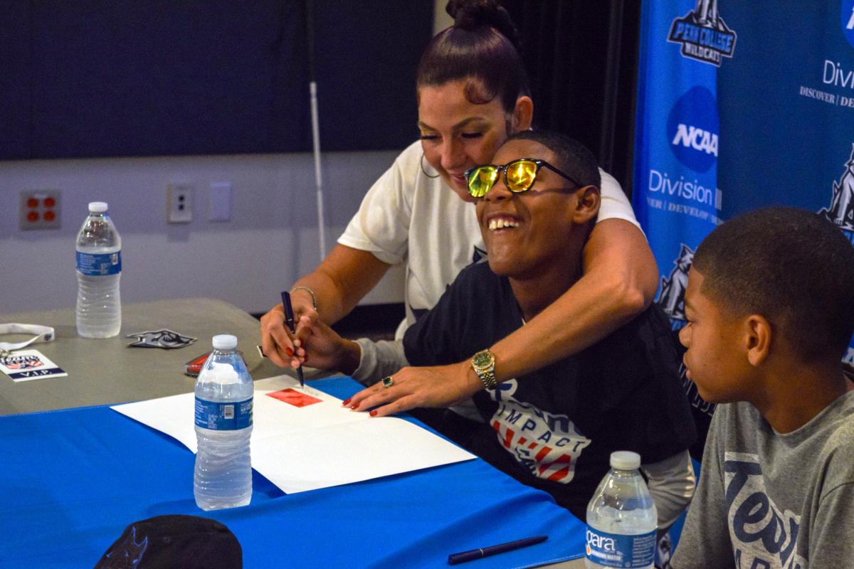 With help from Mom – and a supportive dose of brotherly love from Christopher – Mason completes his letter of intent.