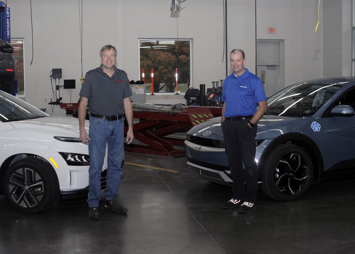 Among faculty members at the forefront of educating tomorrow's electric-vehicle technicians – and standing between two 2023 all-electric vehicles in a Pennsylvania College of Technology lab – are Charles F. Probst (left), the automotive instructor for the college's new three-credit Electric & Hybrid Vehicle Technology course, and Christopher J. Holley, assistant professor of automotive.