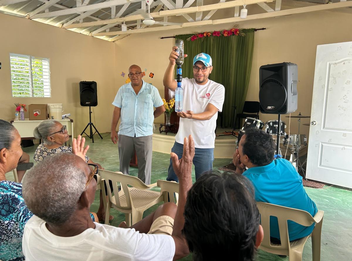 Local residents receive instruction in use of water filters that were distributed by students after a semester-long fundraising campaign back home.