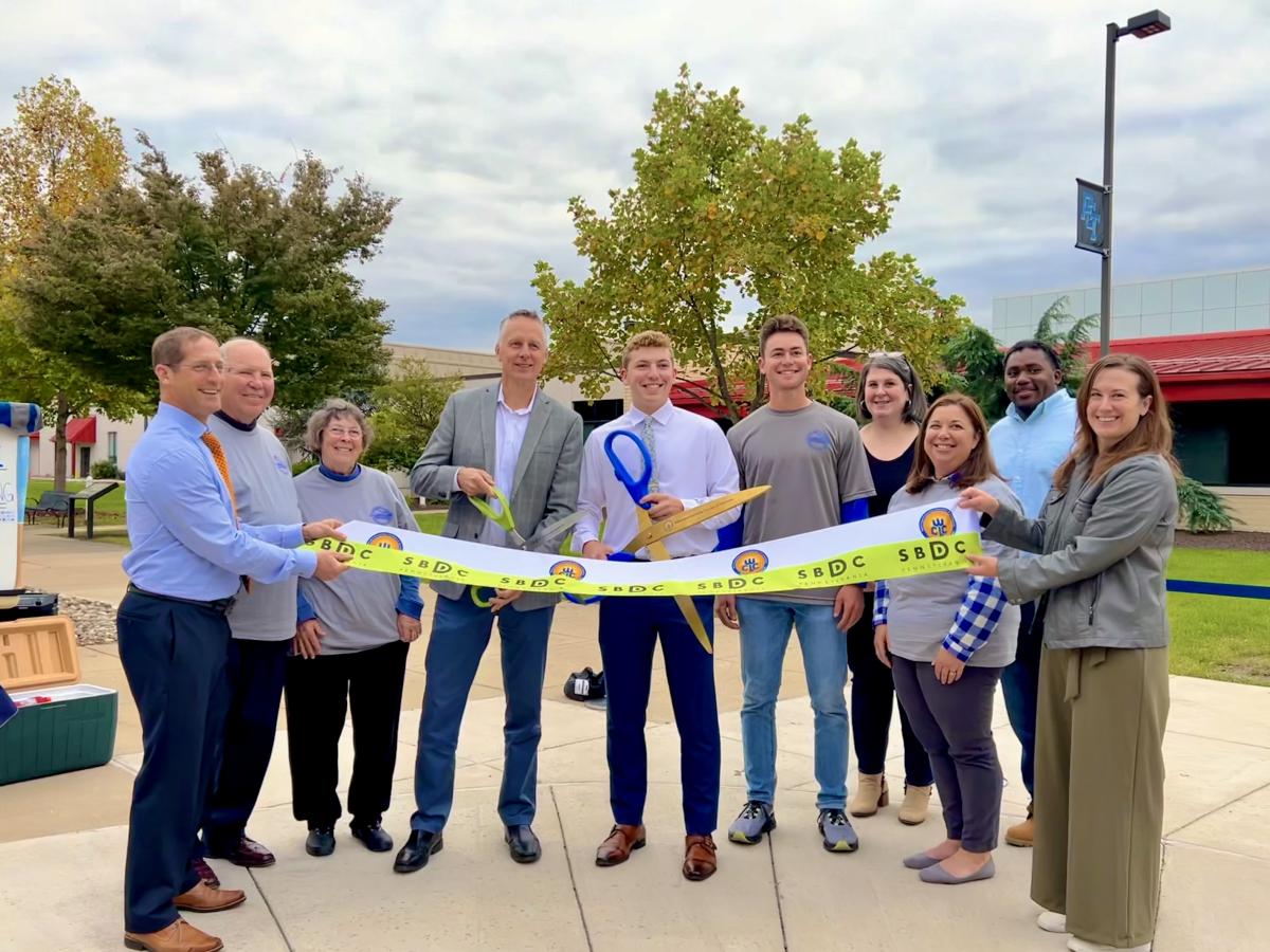 Jason Wiedl and Penn College President Michael J. Reed hold ceremonial scissors, ready to officially open Clubhouse Concessions LLC on Wednesday afternoon.