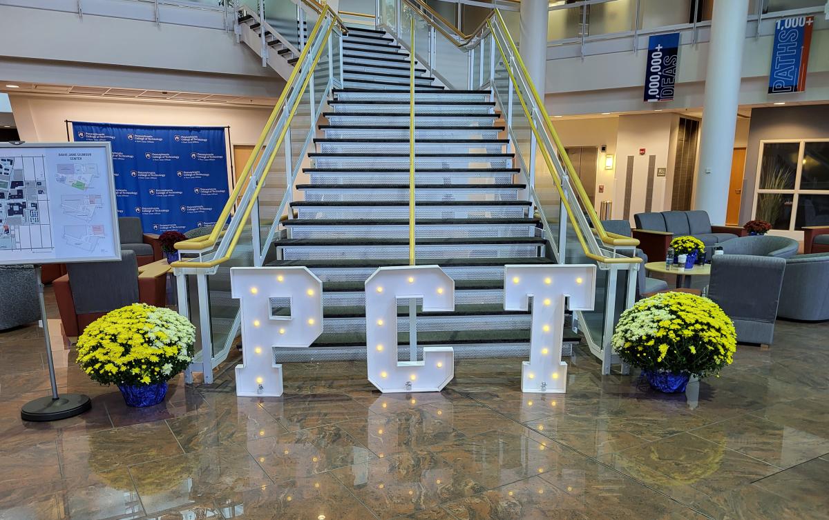 Mums and limelight (and letters created by Datman Productions) accentuate the lobby of the Davie Jane Gilmour Center, filled not long afterward with bustling foot traffic to such offices as Admissions, Financial Aid and the Center for Academic Excellence. (Photo by Tom Wilson, writer/editor-Penn College News)