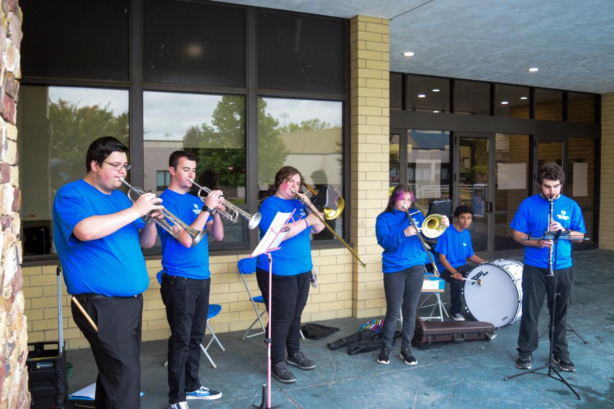 The Penn College Pep Band entertains passersby from under roof, outside the Keystone Dining Room.