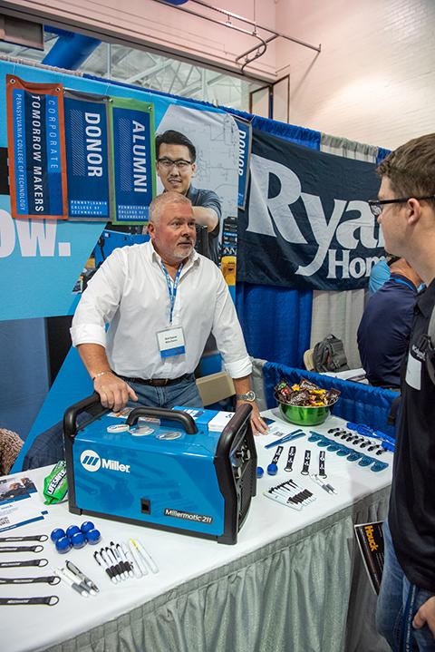 Alumnus Rick Conrad touts Miller Electric in a conversation with welding technology student Grayson H. Kukuchka. Conrad was awarded the college’s Distinguished Alumni Award at the Summer 2022 commencement ceremony.